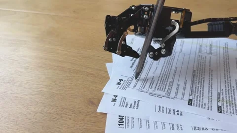 A robotic arm processes a stack of U.S. tax forms, highlighting automation i Stock Footage 265310104