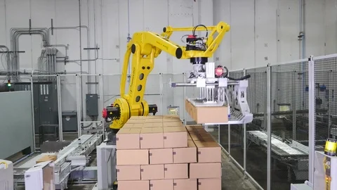 Robotic arm. Stacking boxes onto palette in factory A Vídeos de archivo 101976228