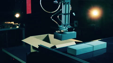 Robotic arm is taking parcels off of the conveyor belt Video stock 143077842