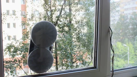 Robotic assistant for home works on the window, wiping glass, freeing owners Stock Footage 205225108