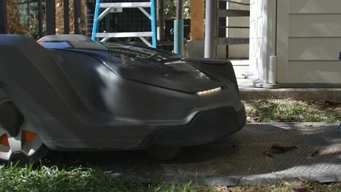 Robotic automower driving into its docking station to recharge batteries Stock Footage 120273385