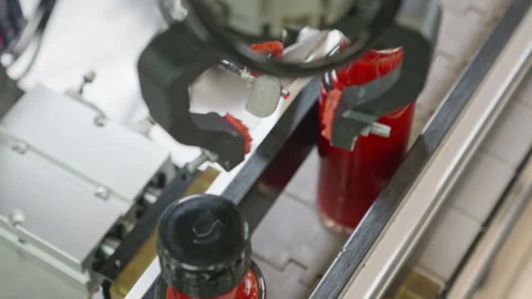 Robotic capping machine closing hot sauce bottles Stock Footage 321804396