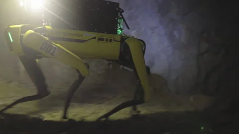 Robotic Dog Traversing Dark Cave Setting During Search and Rescue Mission Stock Footage 157411328