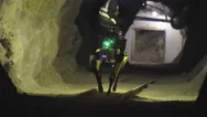 Robotic Dog Walking Down Dark Cave Corridor With Researcher - 4K Stock Footage