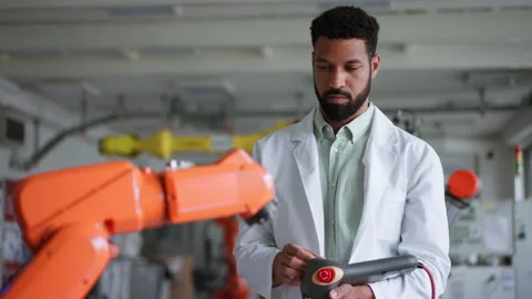 Robotic engineer calibrating or adjusting robotic arm, controlling its actions Stock Footage 277210620