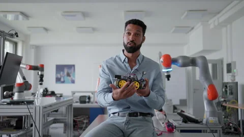 Robotic engineer holding robotic car, explaining its mechanics, power management Stock Footage 277209429
