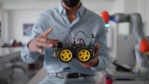 Robotic engineer holding robotic car, explaining its mechanics, power management Stock Footage 277209556