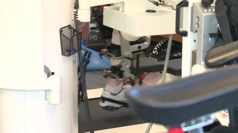 Robotic frames assisting client’s legs to move on the treadmill during session Stock Footage