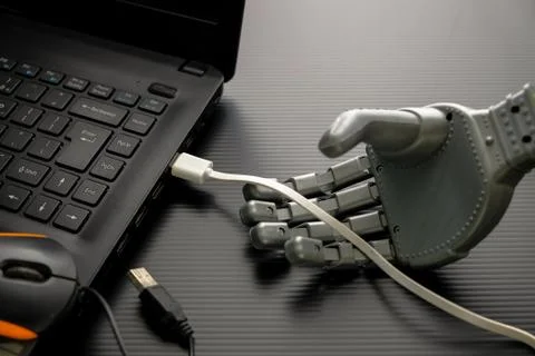 Robotic hand adjusting the USB cable connected to USB port Foto stock