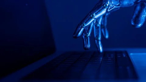Robotic hand glows blue typing on a keyboard Stock Photos