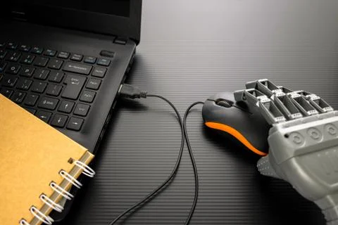 Robotic hand on notebook mouse. Stock Photos
