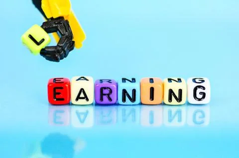 Robotic hand represents machine holding yellow bead. Stock Photos