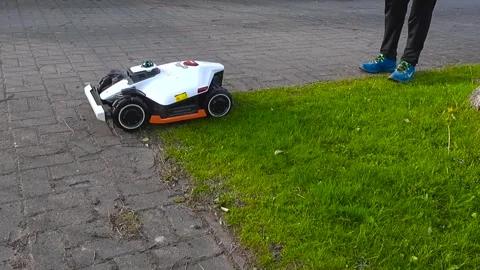 Robotic Lawn Mower Navigating and Set up the Garden Edge Video stock 340848672