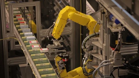 Robotic machine arms. Moving small boxes onto conveyor belt. tight Stock Footage 101706474