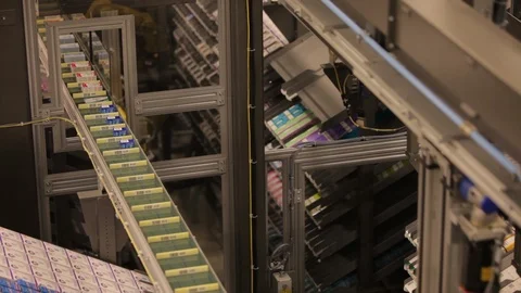 Robotic machine arms. Moving small boxes onto conveyor belt Stock Footage 102186502