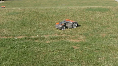Robotic Mower cutting grass on lawn on beautiful summer day, 4k Stock Footage 116745372