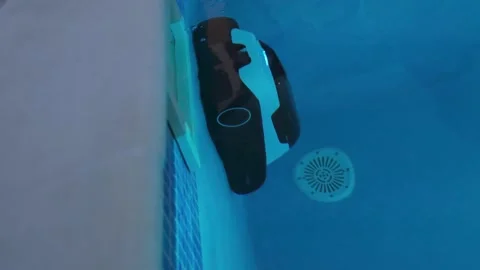 Robotic Pool Cleaner Vacuum Cleaning Swimming Pool at Night with Illuminate.. Stock Footage 346555629