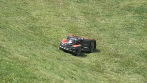 Robotic robot automatic garden mower mowing and cutting a grass lawn Stock Footage 158625689