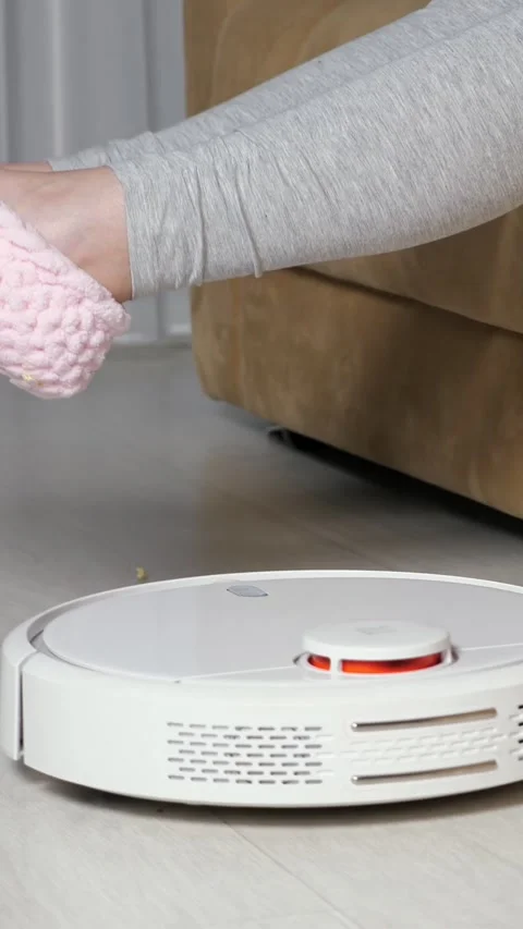 Robotic vacuum cleaner efficiently cleaning a dirty floor with popcorn crumbs Stock Footage 343909230