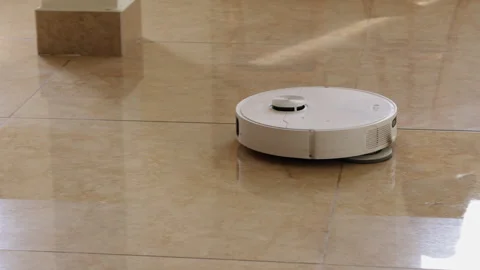 Robotic vacuum cleaner mopping a shiny tiled floor 库存影片 341962143
