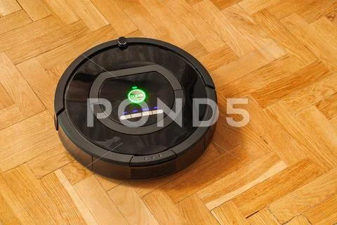 Robotic vacuum cleaner on parquet Stock Photos