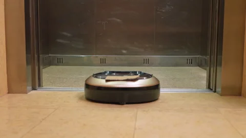 Robotic vacuum cleaner riding into an open elevator Stock Footage 339063446