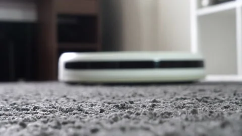 Robotic Vacuum Cleaner  Robot Vacuums Carpet In A Living Room Stock Footage 152306028