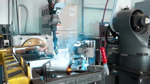 A robotic welding arm is cutting through the metal parts in the workshop room Stock Footage 254204984