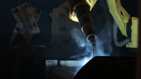 Robotic welding machine in the factory. Dangerous equipment. Welding smoke is be Stock Footage 199486787