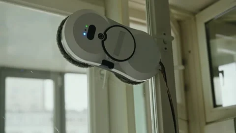 Robotic window cleaner autonomously wiping glass surface, simplifying home Stock Footage 311053768
