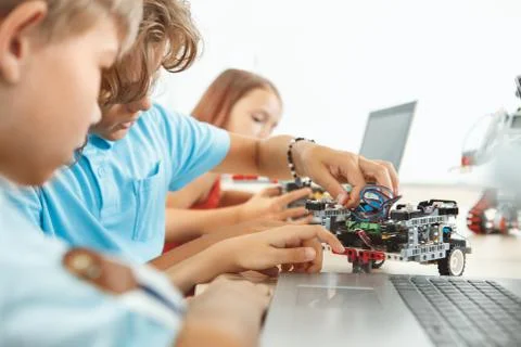 Robotics. Children having class fixing robots cooperating close-up Stock Photos