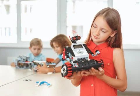 Robotics. Children having class sitting studying while girl close-up looking at Stock Photos