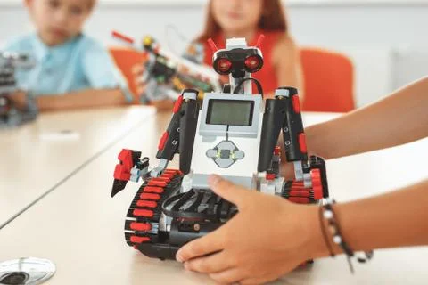 Robotics. Children having class sitting learning kid with robot close-up blurred Stock Photos