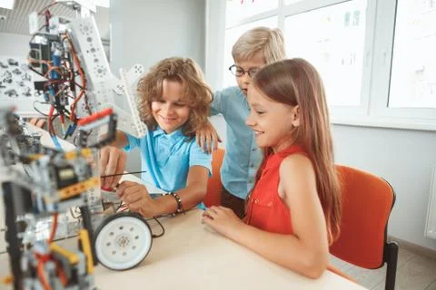 Robotics. Children sitting having class making robots smiling excited teamwork Stock Photos