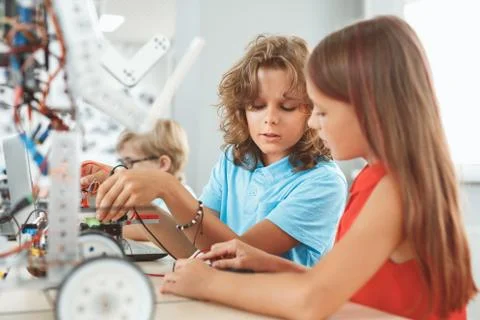 Robotics. Children sitting having class working on robot concentrated Stock Photos