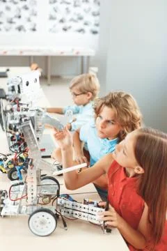 Robotics. Children sitting having class fixing robot concentrated Stock Photos