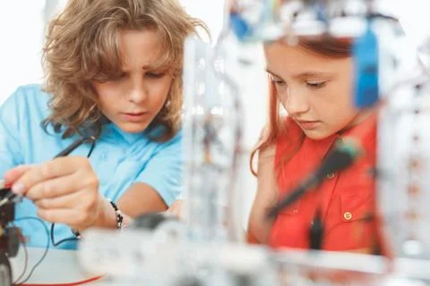 Robotics. Children sitting having class working together on robots concentrated Stock Photos