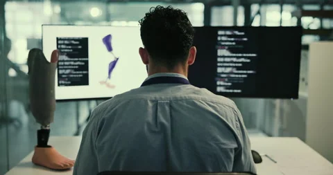 Robotics, development and man at computer screen with prosthetic leg, coding or 動画素材 283606892