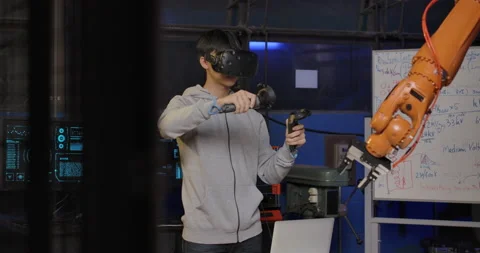 Robotics Engineer Controlling Robotic Arm with a VR Headset Vidéo 153060334