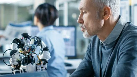 Robotics Engineer Manipulates Voice Controlled Robot, Laptop Shows Code 写真素材