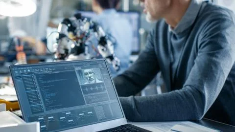 Robotics Engineer Manipulates Voice Controlled Robot, Laptop Shows Code 写真素材