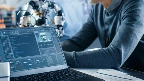 Robotics Engineer Manipulates Voice Controlled Robot, Laptop Shows Code 스톡 사진