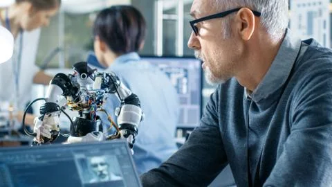 Robotics Engineer Manipulates Voice Controlled Robot, Laptop Shows Code Stock Photos