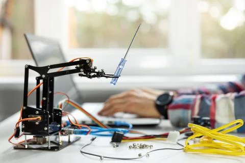 Robotics engineer programming robot arm in office Foto stock