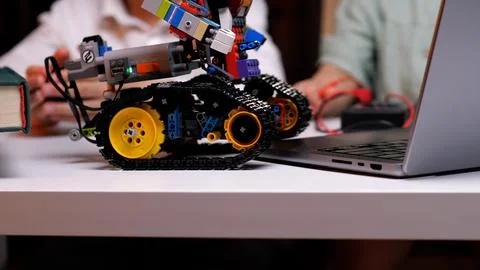 Robotics engineer programming robot vehicle using laptop computer Foto stock