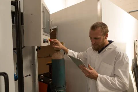 Robotics engineer using digital tablet while controlling control panel 스톡 사진