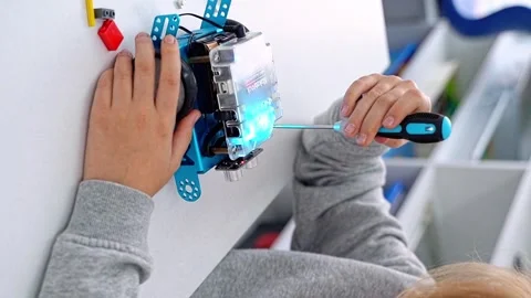 Robotics programming class. Child construct Mbot screwdriver and code Robot Stock Footage 249760639
