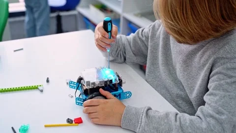 Robotics programming class. Child construct Mbot screwdriver and code Robot Stock Footage 252935484