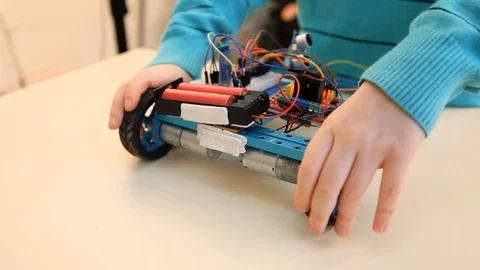 Robotics technology and STEM education class concept: Boy adjusts his robot. Stock-Footage 123132867