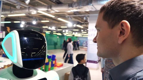 Robotics technology. Guy talk with robot. Robot head with camera scan man 4k Stock Footage 88691130